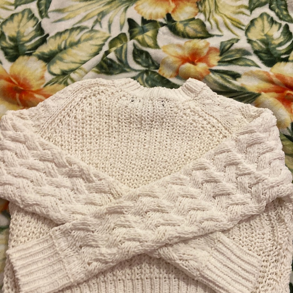 This is a white knitted sweater size extra small in kids